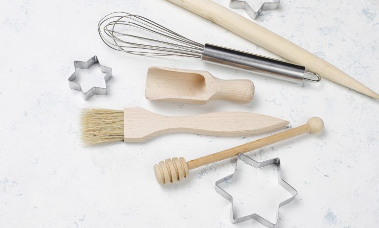 Kitchen baking utensils with spices for cookies and cookie cutters on light background